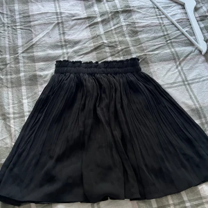 Svart kjol - Svart kjol med struktur, inbyggda shorts