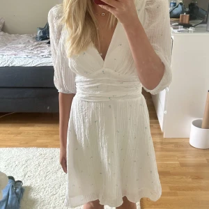 Blommig klänning - Jättefin vit klänning med små blåa blommor, perfekt till midsommar eller i sommar. Använt endast en gång så är som ny
