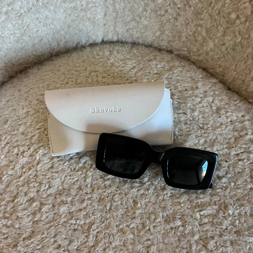 Säljer ett par fina solglasögon från australiensiska märket Shevoke, modell MK ZINGARO NOIR.  Glasögonen är tvåfärgade, svarta utanpå och blå på insidan.  Mått: Lins höjd 35 mm,  lins bredd 45 mm, längd 140 mm. Accessoarer.
