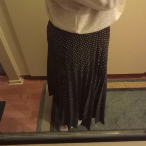 Prickig långkjol - Säljer denna svara långkjolen med vita små prickar på. Säljer då jag inte använder längre. Jag är ca 168 cm lång och den passar min längd perfekt (se bild 1). Köparen står för frakten ☺️