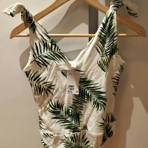 Mönstrad body, oanvänd storlek S - Garderobsrens! Oanvänd body med lappen kvar, från HM i storlek S. Rätt tight i passform så passar kanske dig med XS bättre? Fint somrigt mönster. Perfekt till shorts eller kjol.