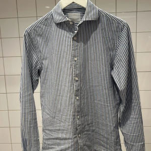 Shirt factory skjorta - Säljer nu min snygga skjorta. Modellen på skjortan är slim och sitter fint. Den ända skadan är lappen i nacken som är lite urtvättad. Den är köpt på NK orginalpris: 1300kr. Hör av er om ni undrar något pris kan diskuteras. 