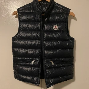 Moncler väst - Säljer min jättefina moncler väst då den är för liten för mig. Den är i super fint skick och inga skador.självklart äkta och köpt på Garmsmarket