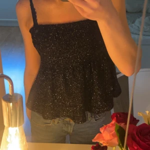 Fest topp - En svart volang tub topp med glitter på, jätte festlig och fin❣️ använd en gång och köpt på Gina men sälja inte längre🥰