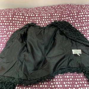 Kappa  - Svart/mörk grön kort kappa inte använd. 