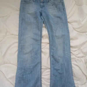 Low waistjeans - Ljublå jeans som säljs då de inte passar. Fint skick och bra pris. Midja 39cm Total längd 103cm Stighöjd 19cm 
