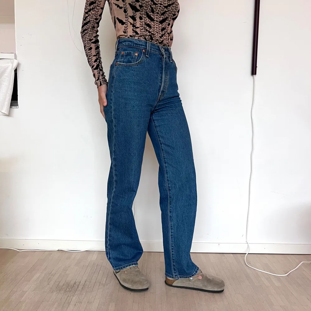 Helt oanvända blå Levi's Ribcage Straight Ankle jeans i storlek 26. Dessa jeans har en hög midja och raka ben, vilket ger en klassisk och tidlös look. De har knappgylf. Perfekta för sommaren men funkar hela året! ☀️. Jeans & Byxor.