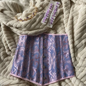 Rapunzel-utklädnad - Säljer korsetten, tiaran och hårklämmorna på bilderna. Perfekt om man ska klä ut sig till Rapunzel! Korsetten är i storlek XS, men går att spänna hårdare/lösare. Allt är fråm shein. Endast använt en gång. Köpt för 200 säljer för 130kr. 