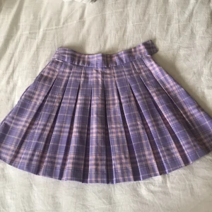 Rosa/Lila kjol - Rosa/Lila volangkjol köpt på Newyorker, använts en gång. Kolla min bio för mer info! 