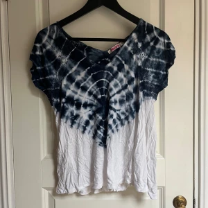 Blå och vit t-shirt - Snygg t-shirt med tie dye-mönster i blått och vitt. T-shirten har en V-ringning och korta ärmar. Den är i en mjuk och bekväm kvalitet.
