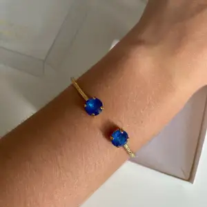 Nytt Caroline Svedbom armband, nypris 500 kr. 18 karats guldpläterad mässing med blå stenar.