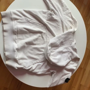 Vit Stone Island hoodie - Tunn och skön väldigt snygg, tyvärr några småhål men dom är lagade. Sitter som en M, säljes då den tyvärr inte passar.