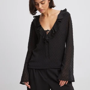 Svart blus från BERSHKA - Söt blus från BERSHKA i storlek 38 sitter rätt löst och är v-skuren. Köptes för 609 kroner och har prislappen och kvittot kvar. ALDRIG ANVÄND säljes pga den inte passar mig och kan inte logga in på mitt Zalando konto. För fler bilder kontakta mig❤️