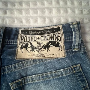 Rodeo crowns jeans - Ett par jättesnygga low waisted jeans. Skulle säga att de är bootcut/straight! Midjan är 80cm och längden är 100cm.
