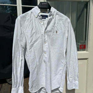 Ralph Lauren Oxford Skjorta - Vit - Vit Ralph Lauren skjorta i mycket bra skick, storlek S. Säljer pga vuxit ur den. Passar dig som är 170-180