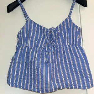 Söt topp - Blå och vit randigt linne med knytdetaljer från H&M. Storlek XS.💕