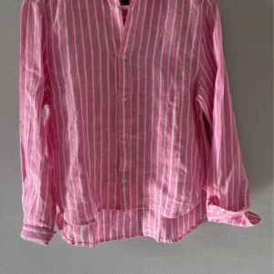 Rosa randig skjorta från Ralph Lauren - Ny, oanvänd linneblus från Ralph Lauren för barn. Storlek ca 150. Lappen sitter kvar.