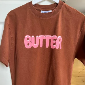 Butter Goods T-Shirt - Brun/Rosa Butter Goods Tshirt i storlek M. Tjockt stabilt material, bra kvalitet. Inga hål eller andra defekter. 