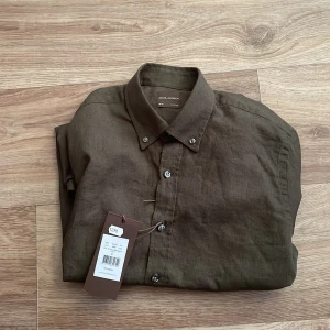 Oscar Jacobsson Skjorta strl S - Helt ny o oanvänd grön Oscar Jacobsson linneskjorta i strl S. Nypris 1300 kr. Passar perfekt för sommaren. Passar i längderna 168-180cm. //AR