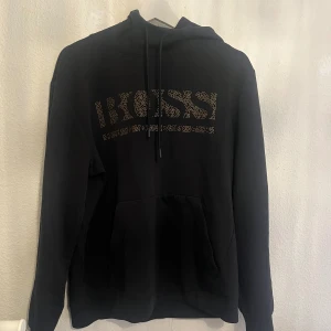 Boss hoodie - Svart hoodie med guldig text i bra skick. Strl m