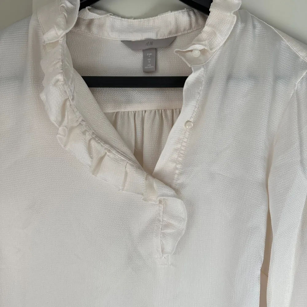 Snygg vit blus med krus H&M storlek s. Aldrig använd.. Blusar.