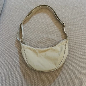 Uniqlo Shoulderbag  - Shoulderbag från Uniqlo. Så rymlig, dessutom med två fack inuti. Har ett justerbart axelband som kan både göras väldigt långt samt hyfsat kort. Knappt använd men har fått en liten fläck på sista bilden (har ej testat att ta bort)💗