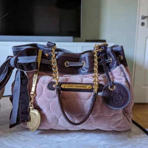 Väska Juicy Couture  - Väska från Juicy Couture. Inköpt i Santa Monica för 14 år sedan. Special Edition, gjordes i begränsad upplaga. Mycket fint skick då den mest stått i hylla som dekoration. Fler bilder finns om så önskas