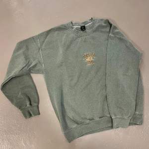 Sweatshirt Colorado Springs från Urban Outfitters, storlek S. Grågrön färg. Mycket bra skick.   Avslappnad passform med nedhasade axlar. 