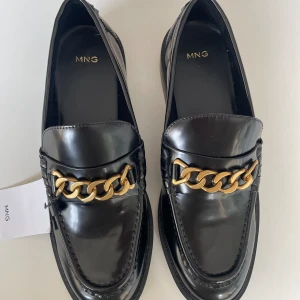 Nya svart loafers - Aldrig använda svart damloafers med guldkedja