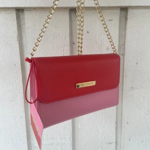 Juicy Couture vintage väska💘 - En snygg vintage Juicy Couture som inte säljs längre! Har fått den som en gåva men helt oanvänd med prislappen kvar❤️cirka 20 cm lång och 12 bredd! Kommer med ett lång guld kedja till😍Och 4 innerfack som man kan ha sina små behövligheter i! 