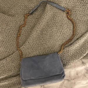 Blå väska - Säljer den här jätte fina väskan då den tyvärr inte kommer till användning💕 den är bara använd en gång och är i mocka material. Köpt för 500🤍