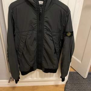 Säljer nu en riktigt snygg jacka från Stone island. Den har ett litet hål som går att laga. Även en liten lagning på ryggen. Annars väldigt snygg med luva.