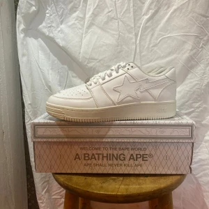 Bapesta Low M2 White Leather 2020 - Tjena säljer ett par riktigt sköna Bapesta low M2 White Leather 2020. 110% äkta digitalt kvitto finns.  Storlek:42 Skick: 8/10 Om du har några frågor, funderingar eller vill ha fler bilder är de bara att skriva till mig. 