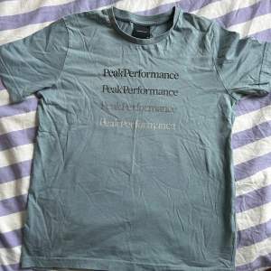 Säljer åt min bror då han växt ur. Peak performance t-shirt i en ”smuts” blå/grön/gråaktig färg i storlek 160. Bra skick. Säljs för 80kr