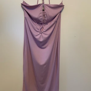 Klänning - En klänning som utan axelband, man knyter den framtill. Ny med prislapp