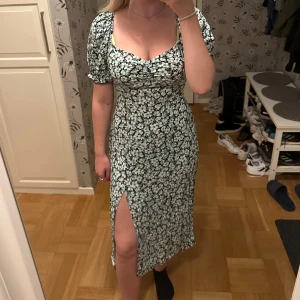 Klänning  - Blommig klänning med slits
