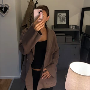 Tunn kappa  - Säljer denna super fina brunbeiga kappa. Köpt för 1500kr från Stockholm LM men säljer för 600 kr. Bandet är borttaget pga att det inte kom till användning, landet finns alltså inte kvar.