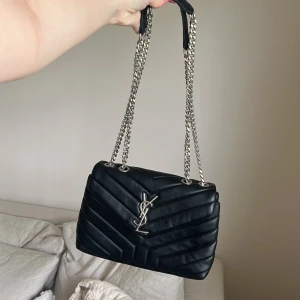 Väska ysl  - Knappt använd, har inget äktahetsbevis så vet inte om den är äkta. Men verkligen fin och ser precis likadan ut. Perfekt storlek går att ha båda banden på axeln och även göra det långt 