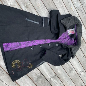 Desigual kappa - Desigual figursydd ullkappa med löstagbar krage, fina detaljer i skinnimitation. Använd med i mycket fint skick med lite slitage på fickorna. Inköpt för 2200 sek.