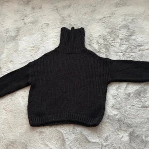 Svart sweater med polo krage - Svart stickad tjocktröja med krage från H&M. Normal i storlek, använd fåtal gånger men som ny. Kliar inte, varm och skön och i fint skick. Storlek XS men passar S också. Säljer på grund av att jag aldrig använder den mer.