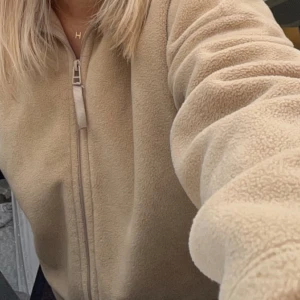 Fleecetröja  - Beige fleecetröja med dragsko i midjan från Gina Tricot💕, nästan aldrig använd och köpt för något år sedan. Följer med en croppad teddyjacka om man vill det🩷💫 