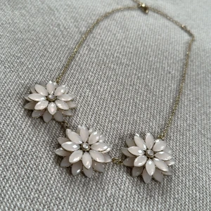 Halsband med 3 större ljusrosa blommor - Halsband med 3 stora blommor i ljusrosa. Halskedjan är guldfärgad. Aldrig använt. 