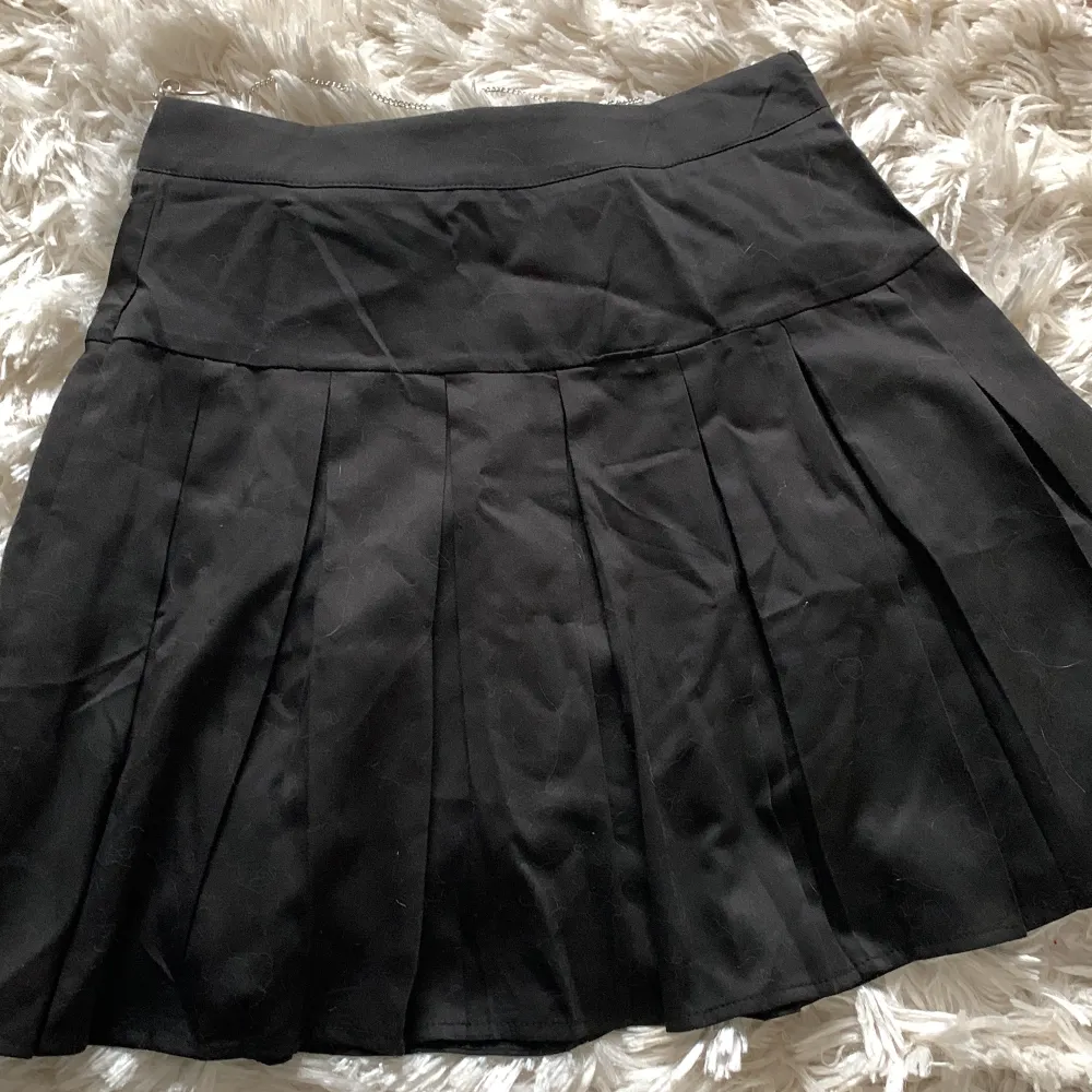 svart plisserad kjol med avtagbar kedja . Kjolar.