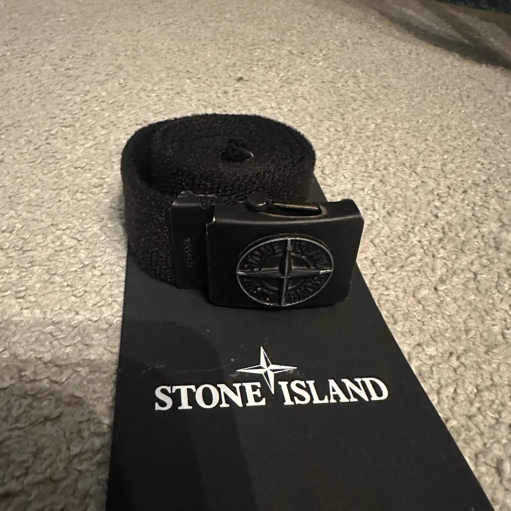 Säljer du detta Stone island bälte som är köpt på nk i Stockholm. Bältet är ca 95cm långt och är i väldigt bra skick. Tyvärr har jag inte kvar hela boxen utan bara det som finns på bilden. Skriv om du funderar över något.. Accessoarer.