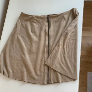 Kjol med dragkedja framtill  - Kjolen har en dragkedja på framsidan och är i mocka material. Kjolen är i väldigt fint skick.⭐️