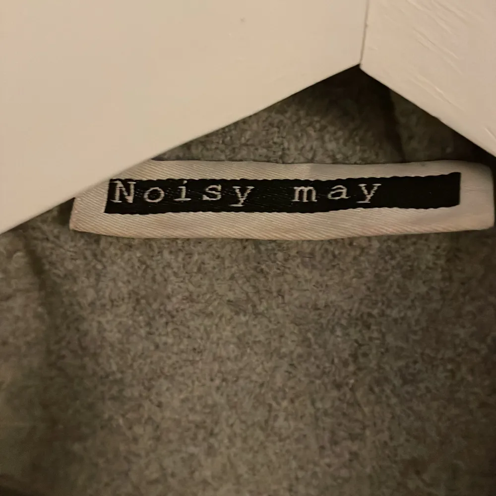 Jättefin ljusgrå kappa i storlek s från Noisy May.Perfekt till våren,är inte smutsig eller trasig.Konner med ett band man kan knyta runt och har även en knapp man kan stänga.. Takit.