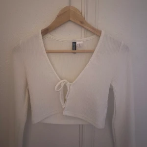 Vit kofta med rosettsnörning - Säljer min vita kofta från H&M i storlek XS. Den är kroppad och i nyskick utan prislapp, perfekt nu till våren. Kom gärna med prisförslag 💗