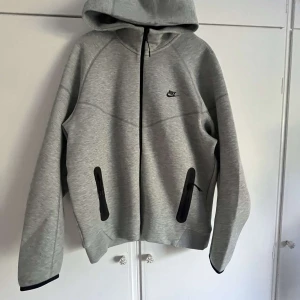 Nike tech fleece hoddie herr  - Storlek:XL  Skick: Som nyskick  Passform: normal passform  Färg: Grå med svarta detaljer  Köpt: 8 maj 2024 ( JD sports )  Använd: Bara en gång Nypris: 950kr  
