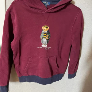  Vinröd polo Ralph Lauren hoodie -  Denna vinröda polo Ralph Lauren hoodie är i utmärkt skick och väldigt stilren. På hoodien framkommer polar Ralph Lauren signatur Björn. 