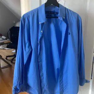 Säljer nu denna blåa snygga skjortan från RL. Skjortan är i M och är perfekt nu till sommaren. Skjortan har inga defekter över huvudtaget, bara att skriva om man har några funderingar, priset är inte hugget i sten! 